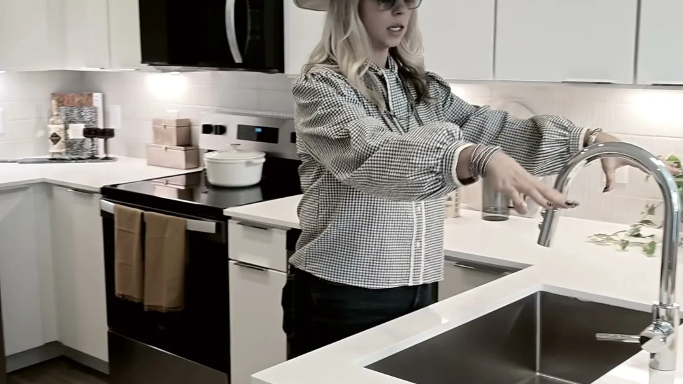 A member agent walks a client through the kitchen of a new listing, filmed by the studio.