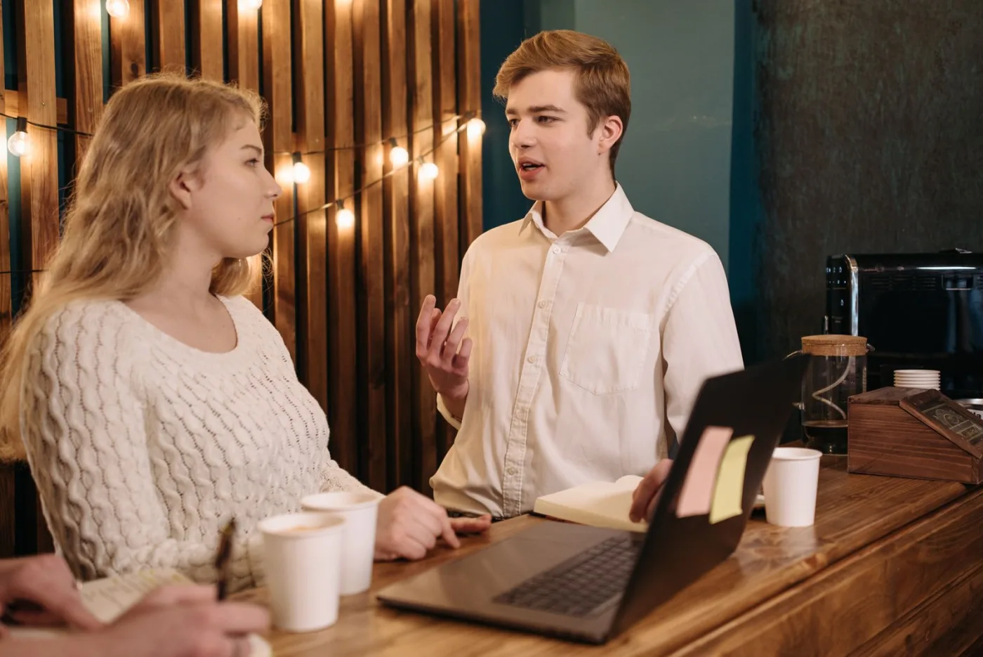 A newer agent listens across the table while the mentor talks it through.