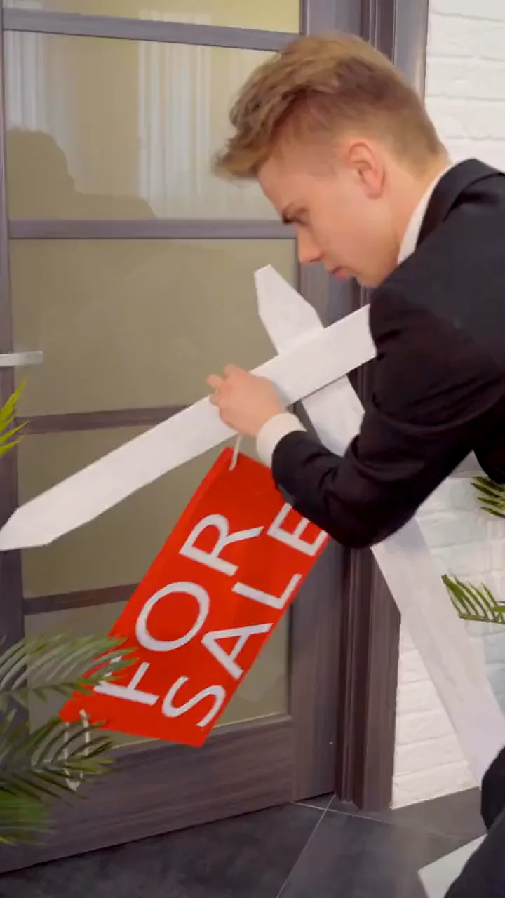 An agent plants a For Sale sign outside a listing.