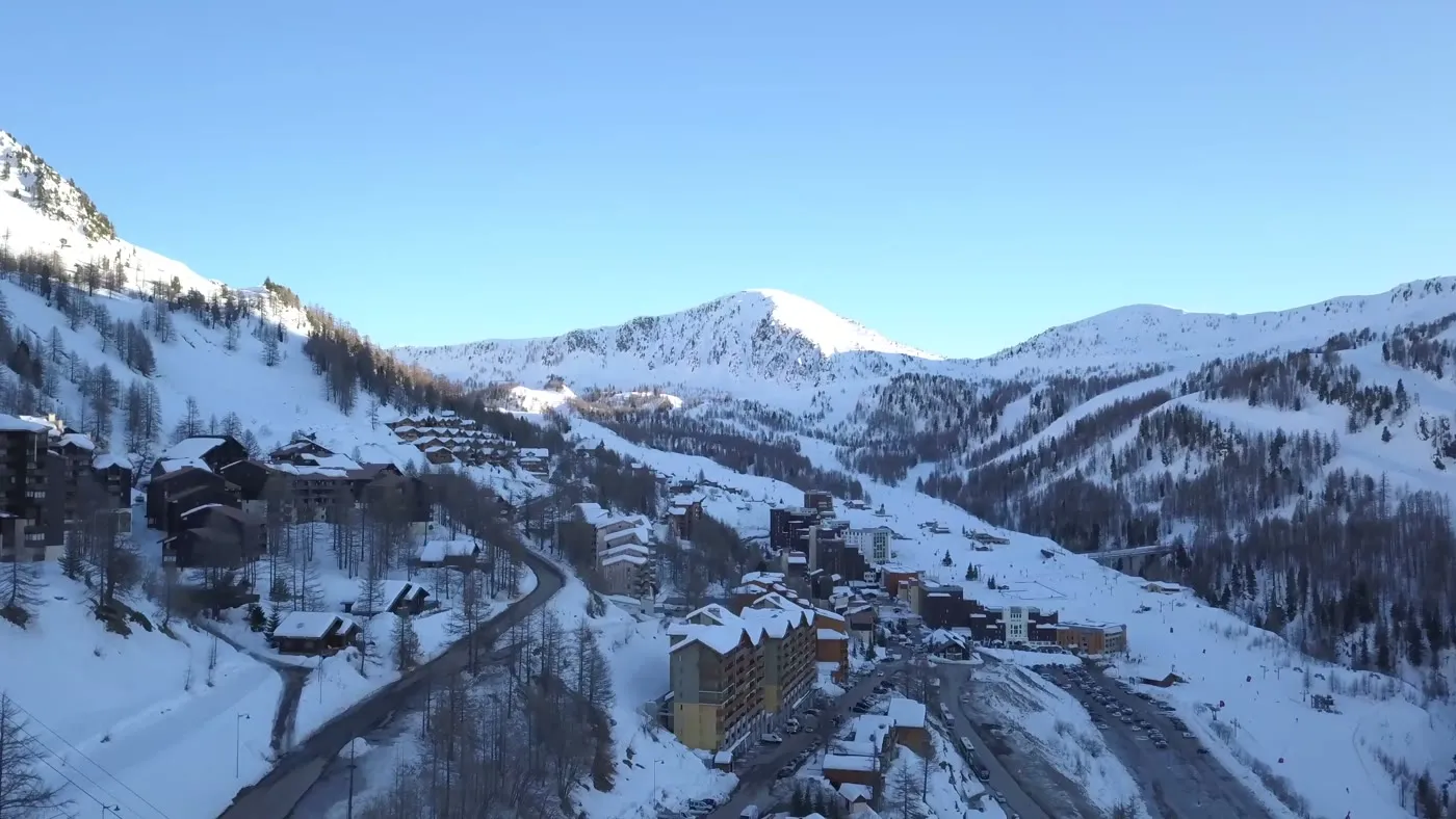 Aerial view of a snow-covered alpine village, a winter retreat destination.