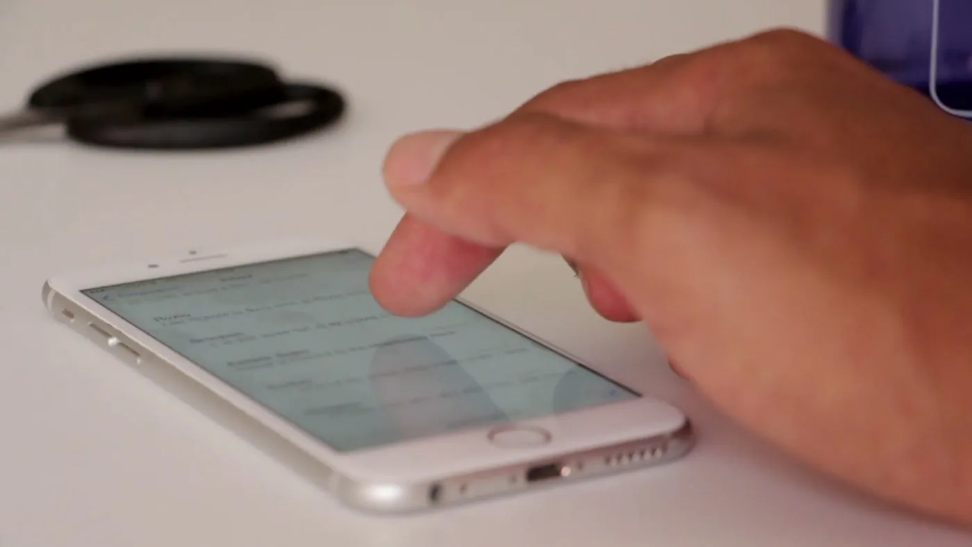 A finger works through a phone inbox, one message at a time.